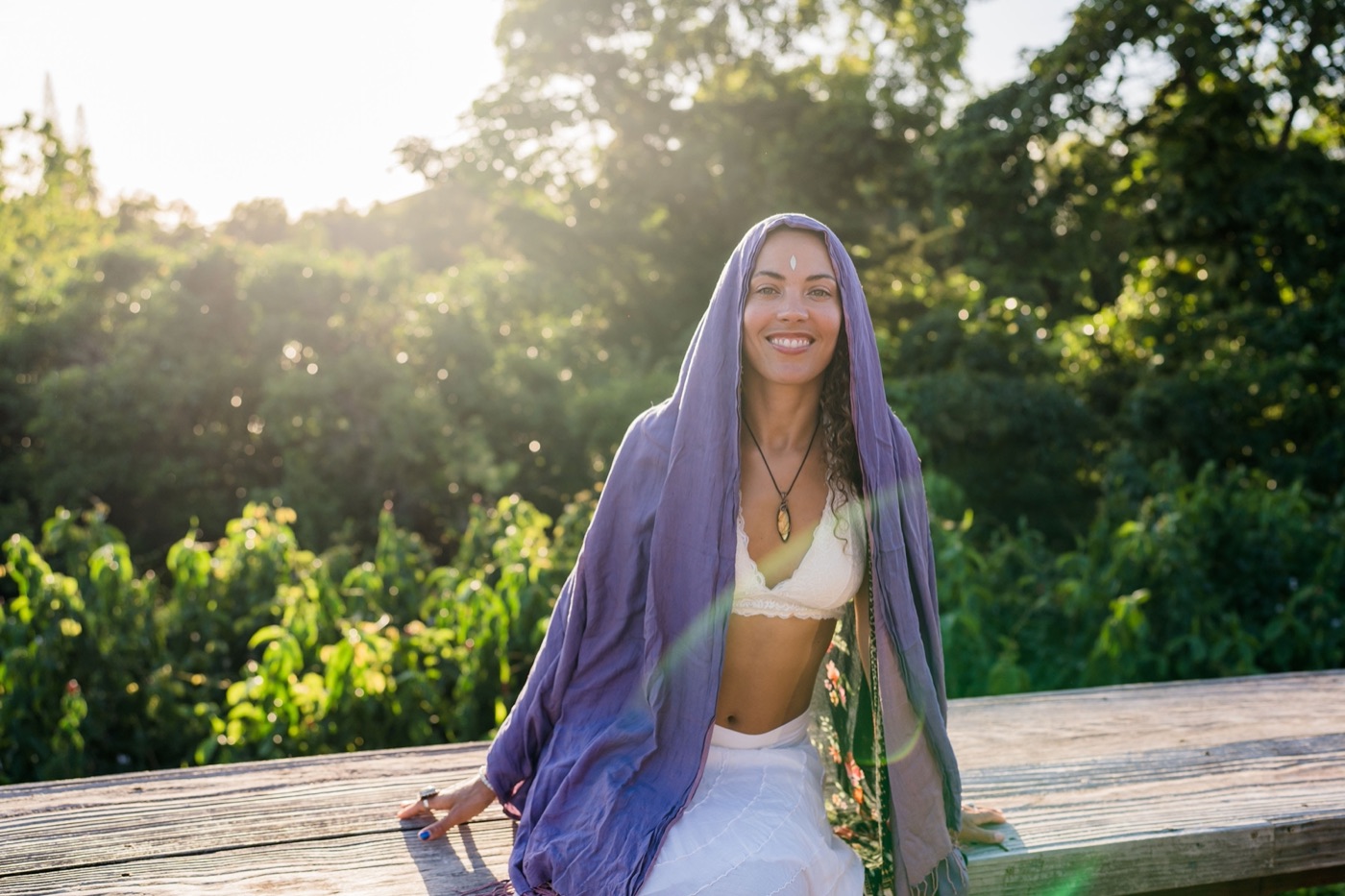 Donica smiling softly in a lavender veil, bathed in golden light